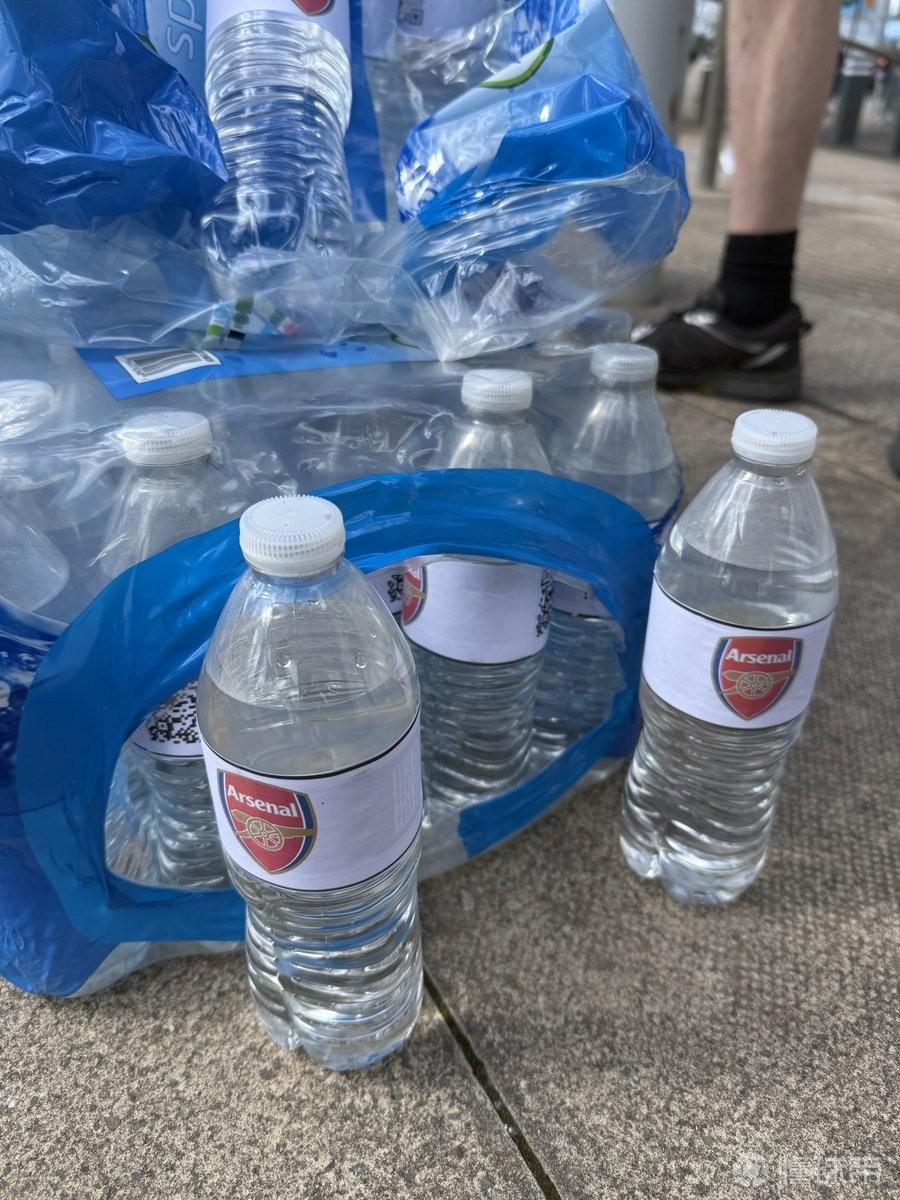紧跟热点，曼城球迷在球场外出售贴有阿森纳队徽的水瓶